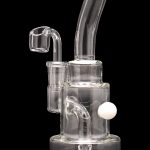 Clear glass dab rig with a quartz banger and pearl, isolated on a black background.