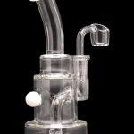 Clear glass dab rig with white accents, featuring a bubbler and quartz nail.