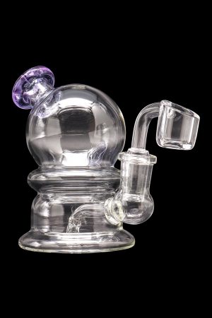 Clear glass dab rig with purple accents, featuring a spherical percolator and quartz banger.
