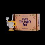 A wooden cannabis water pipe displayed alongside a decorated box labeled “Hemper Tea Party Box: Quality Smoking Supplies.”
