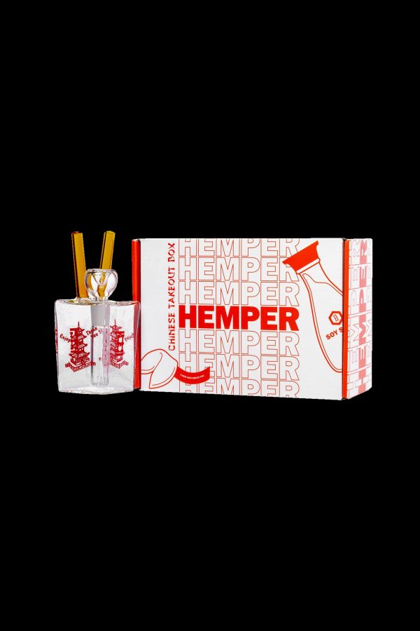 A glass bubbler pipe inside a Chinese takeout-style box branded with “Hemper” and cannabis leaf designs.