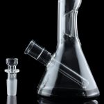 Clear glass water pipe (bong) and detachable downstem, reflected on a black surface.