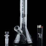 Clear glass bong with a removable bowl and lighter beside it, studio shot.