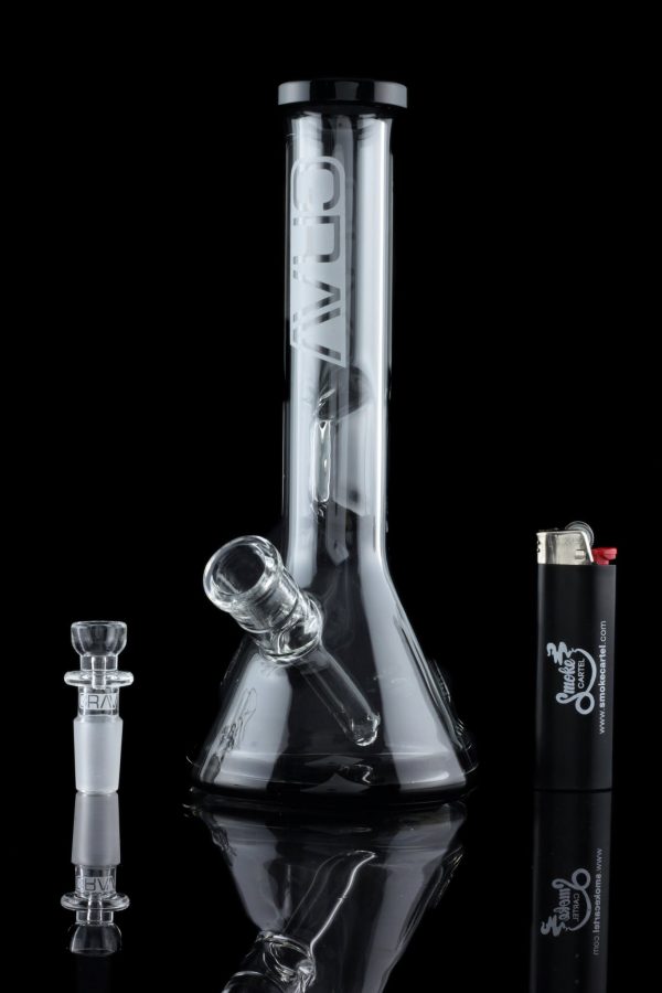 Clear glass bong with a removable bowl and lighter beside it, studio shot.