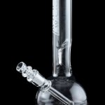 Clear glass water pipe (bong) with intricate design, studio shot on black background.