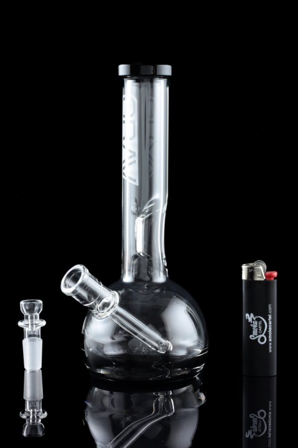 A glass water pipe (bong) with a clear glass bowl and accompanying accessories, reflected on a black surface.