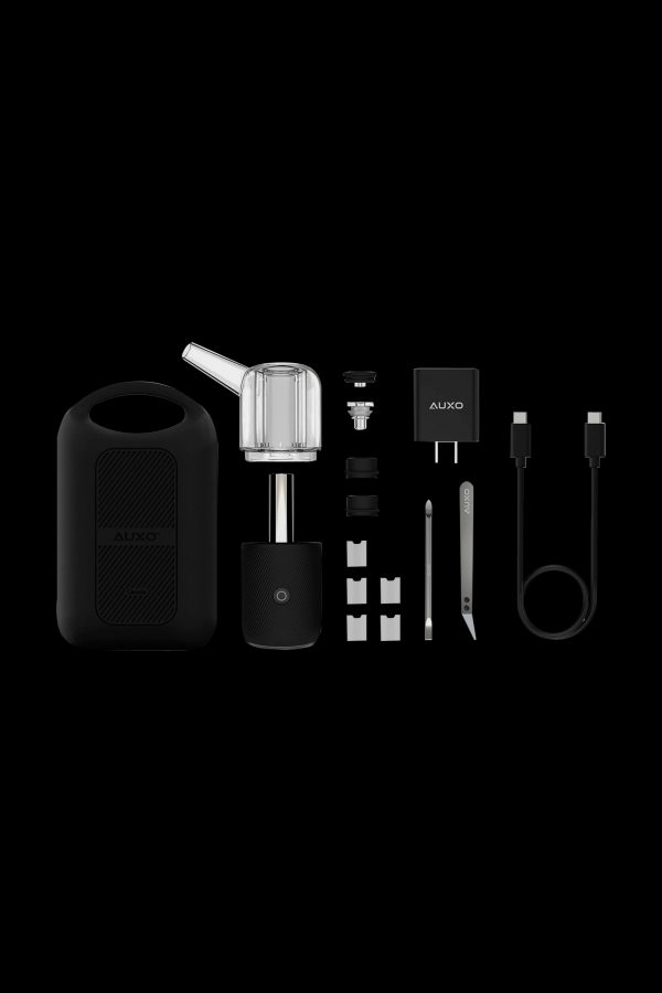 Auxe cannabis vaporizer kit laid out on a black surface, including the device, glass chamber, charging cable, and various accessories.
