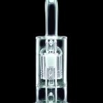 Glowing green glass dab rig against a black background.