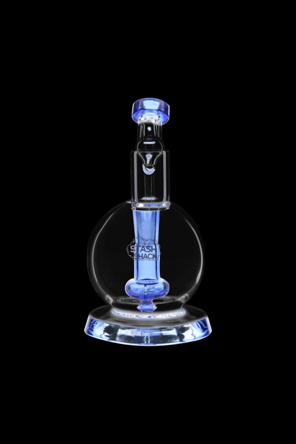 Blue glass dab rig with intricate design, illuminated against a black background.
