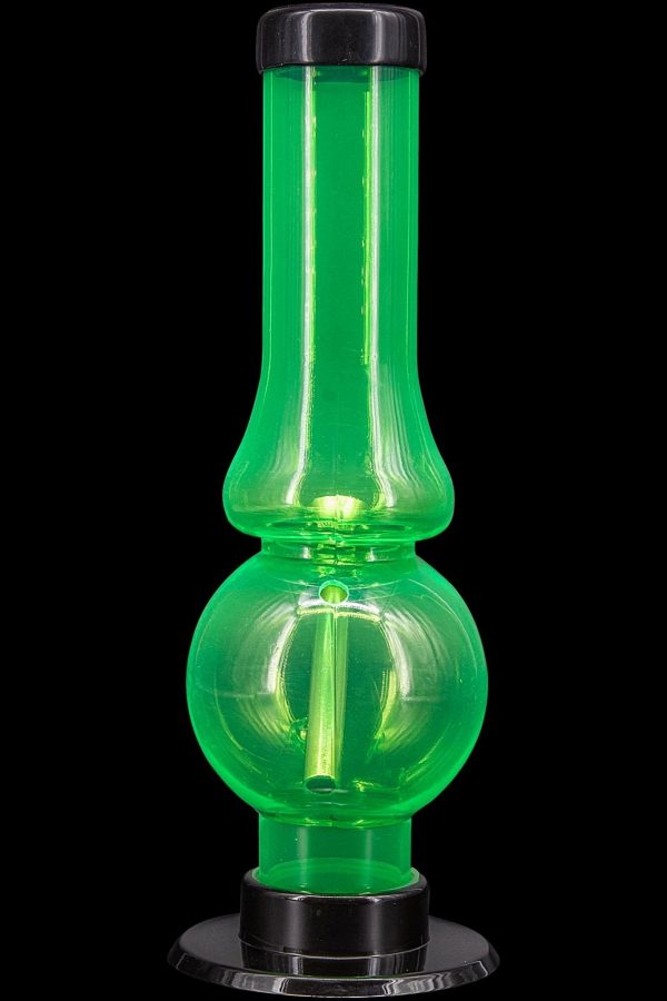 Glowing green glass water pipe, also known as a bubbler, on a black base.