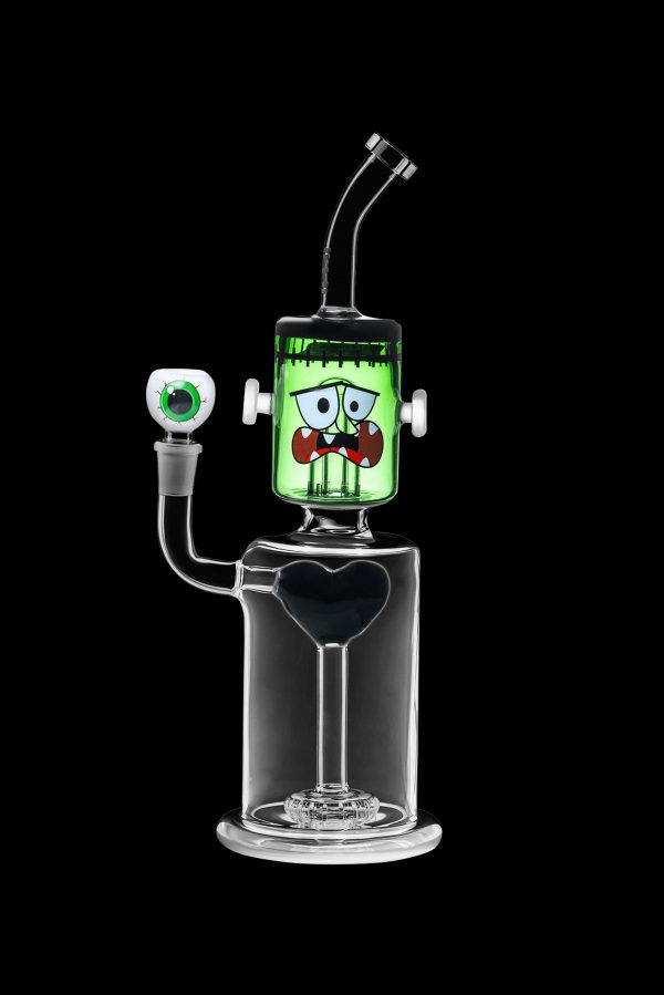 Glass water pipe shaped like Frankenstein's monster with a clear base and green head, isolated on a black background.