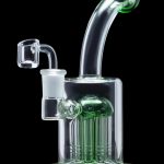 Green glass dab rig with multiple percolators, isolated on a black background.