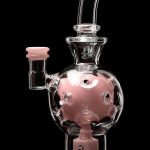Pink glass water pipe (bong) with intricate bubbler design.