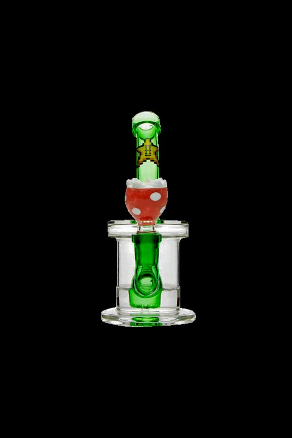 Green and red glass dab rig with percolator, isolated on a black background.