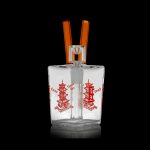 Clear glass bubbler water pipe with red pagoda design and orange mouthpiece.