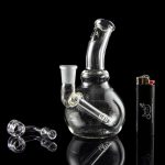 A studio shot of the LA Pipes Mini Bubble Base Concentrate Rig, reflecting on a dark surface with a sleek, modern aesthetic.