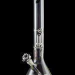 Clear glass bong with intricate percolators, reflecting on a black surface.