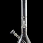 Clear glass bong with intricate percolator, isolated on black.
