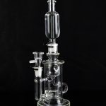 Clear glass water pipe (rig) with multiple chambers and a glass bowl, isolated on black.