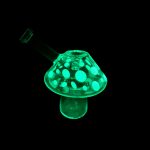 Glowing green glass mushroom-shaped oil rig for cannabis concentrates.