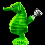 A front view of the Premium Silicone Seahorse Molded Water Pipe, showcasing its green, sculpted form against a dark reflective surface.