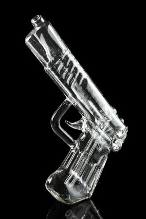 Clear glass pipe shaped like a handgun, reflecting on a black surface.