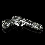 Glass pistol-shaped cannabis pipe on a reflective black surface.