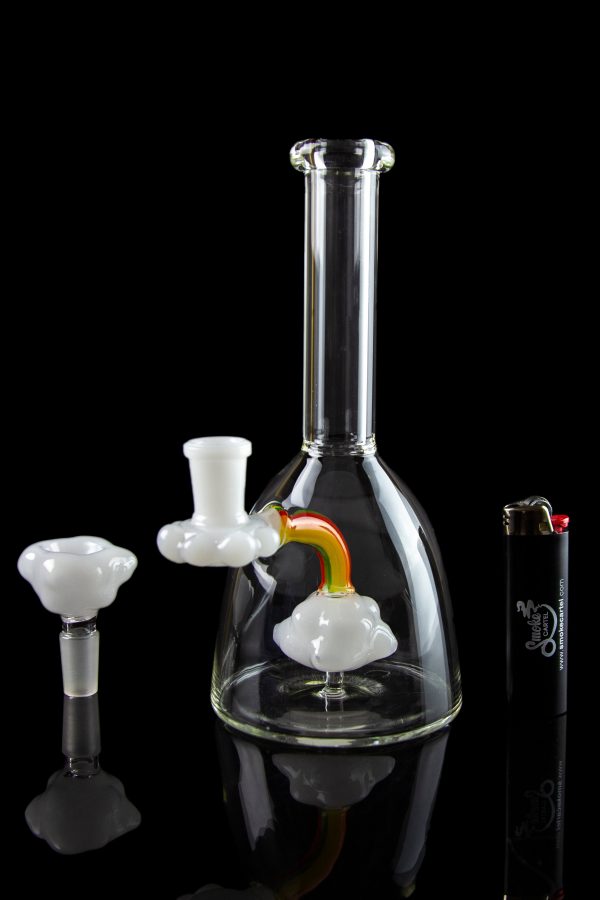 Clear glass water pipe (bong) with colorful attachments, displayed on a reflective surface against a black background.