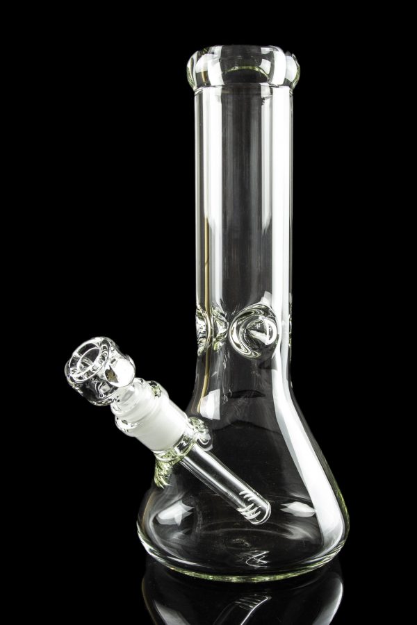 Clear glass bong with a downstem, reflecting on a black surface.