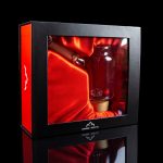 A sleek, red display box showcases a glass cannabis water pipe, reflecting on a glossy surface with “Canada Puffin” branding.