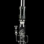 Clear glass water pipe (rig) with intricate bubbler design, isolated on black.