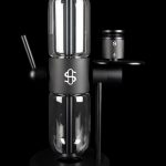Sleek black cannabis oil vape pen and cartridge with a dollar sign logo, studio shot.