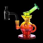 A colorful glass dab rig with a quartz banger, isolated on a black background.
