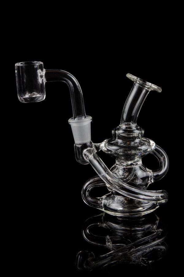 Clear glass dab rig with intricate looping design and quartz banger, isolated on black.
