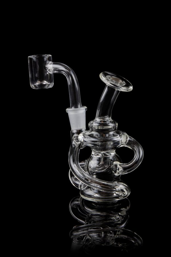 Clear glass dab rig with intricate looping design, against a black background.