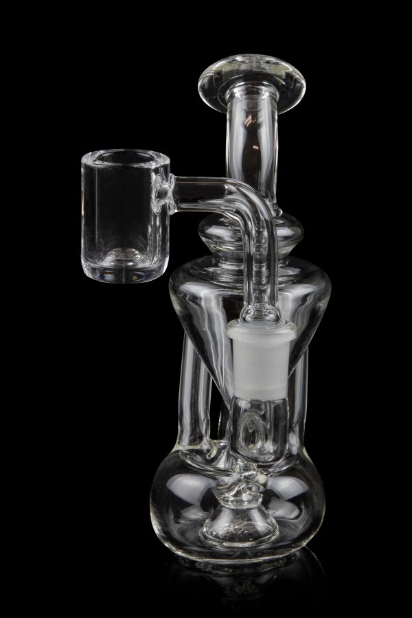Clear glass dab rig with a quartz banger, isolated on a black background.