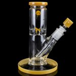 Clear glass water pipe (bong) with gold accents and a cannabis-themed decal, isolated on a black background.