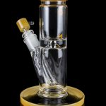 Glass water pipe (bong) with a flared base and amber accents, against a black background.