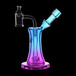 Colorful glass dab rig with quartz insert against a black background.