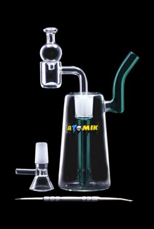 Clear glass rig with percolator and detachable mouthpiece, alongside a glass bowl, on a dark surface.