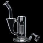 Clear glass dab rig with accompanying nail and carb cap, isolated on black.
