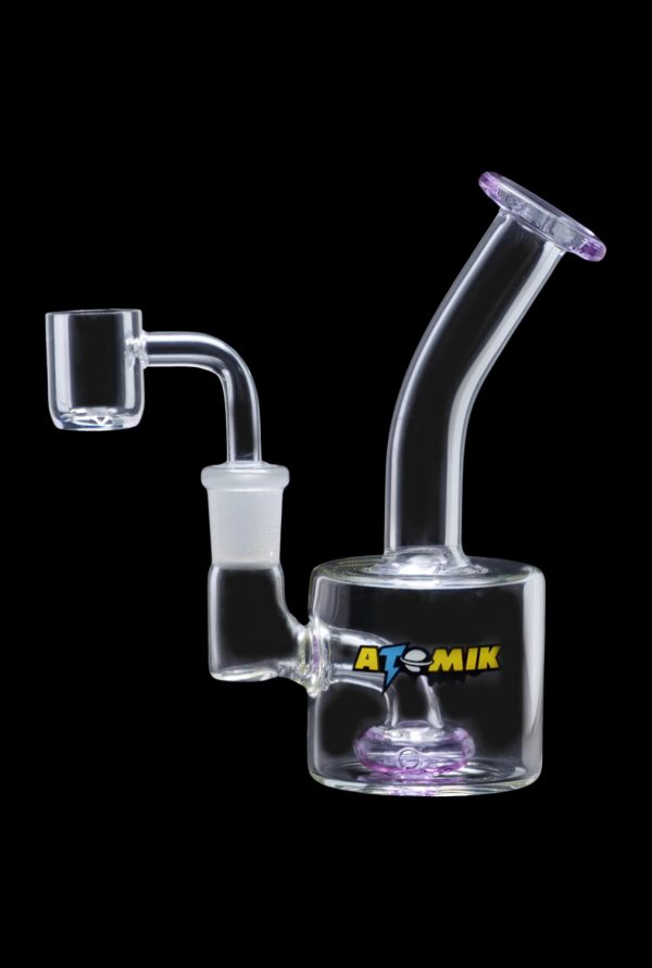 A side view of the Atomik Little Dipper Dab Rig showing the clear glass construction and angled neck.