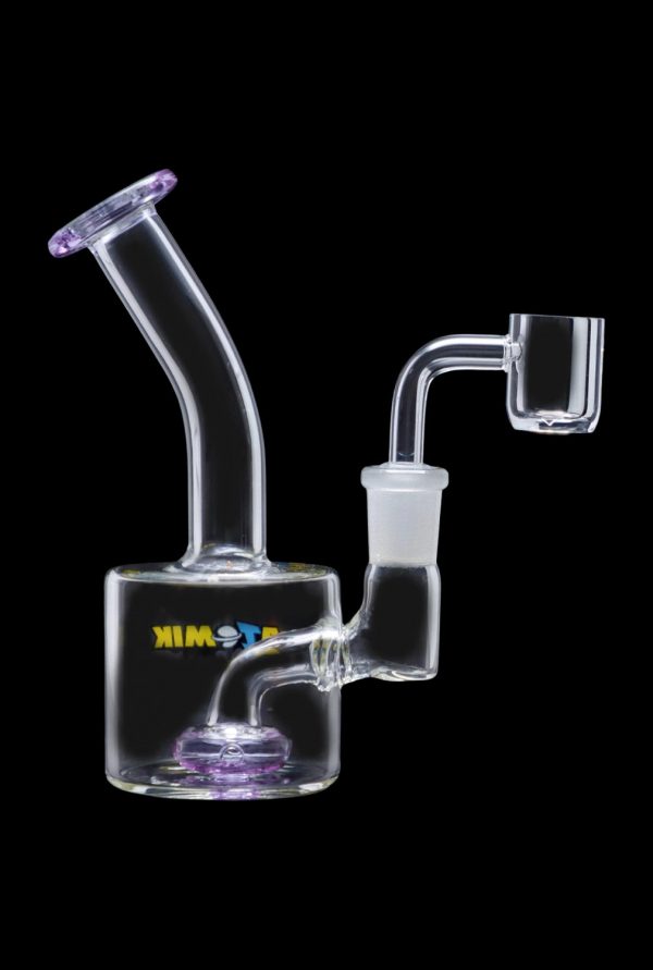 The Atomik Little Dipper Dab Rig is shown in a side view, highlighting its clear glass construction and compact size.