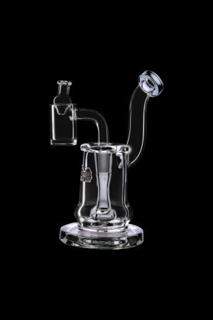 Clear glass dab rig with a quartz banger and intricate swirling design, isolated on a black background.