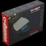 The Truweigh Sonic Digital Mini Scale is shown in a close-up, angled shot with a black background and visible digital display.