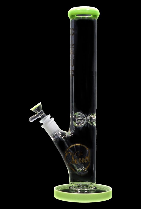 A green-accented glass bong with a clear tube and intricate etched design.