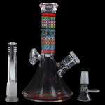 A colorful glass water pipe (bong) with Egyptian-inspired designs, displayed with a downstem and a separate glass piece, against a black background.