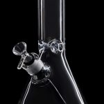 Clear glass bong with a downstem and bowl against a black background.