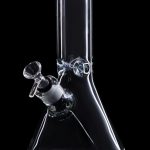 Clear glass bong with a green mouthpiece and ice catcher, isolated on a black background.