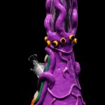 Purple glass water pipe shaped like an octopus with multiple eyes, against a black background.
